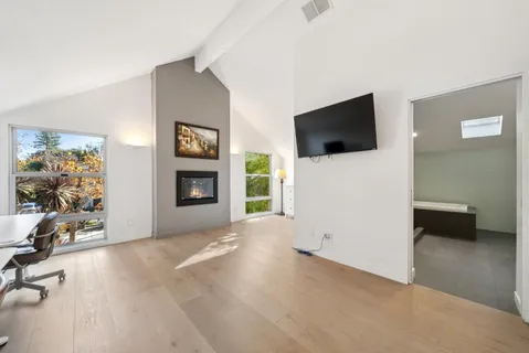 a view of a kitchen with white cabinets and wooden floor