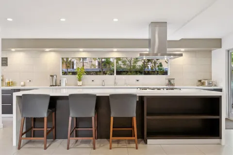 a large kitchen with a large window and stainless steel appliances