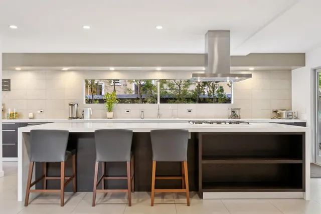 a large kitchen with a large window and stainless steel appliances