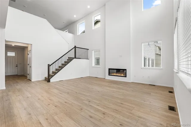 a view of a livingroom with wooden floor and a ceiling fan