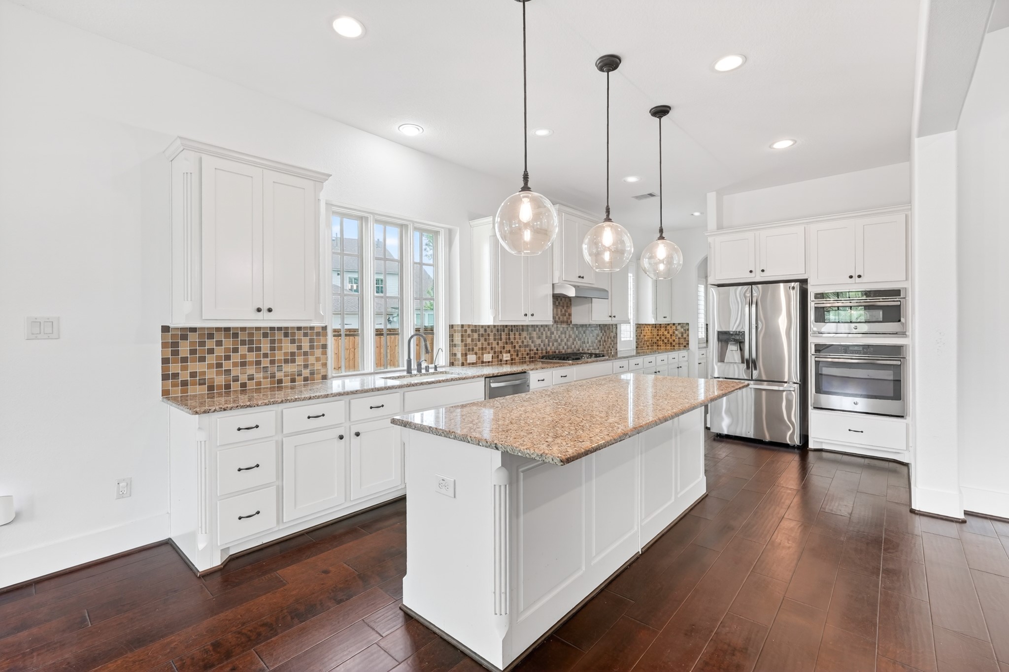 27 Hedgedale Way Spring, TX 77389 - Photo 16 of 49 a large kitchen with granite countertop a large kitchen island white cabinets and stainless steel appliances