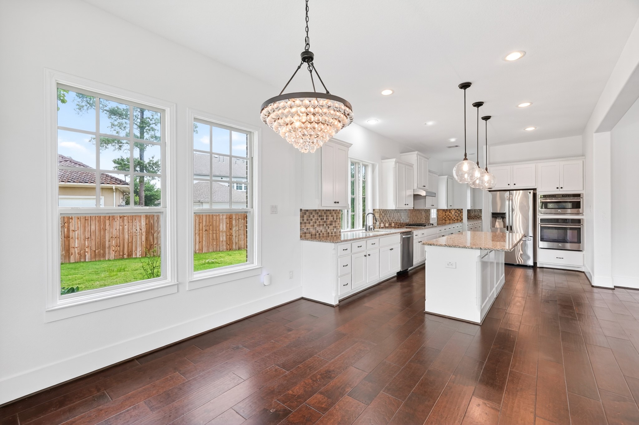 27 Hedgedale Way Spring, TX 77389 - Photo 20 of 49 a large kitchen with white cabinets and wooden floor