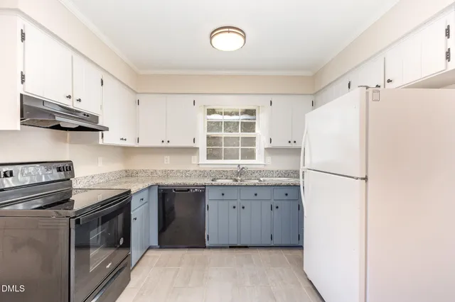 a kitchen with granite countertop a sink stove a refrigerator and a sink