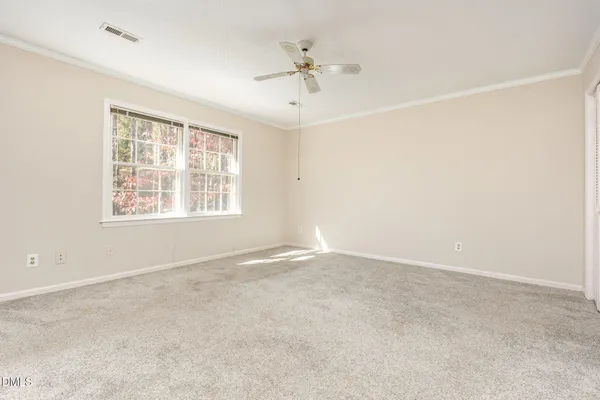 an empty room with a window and a ceiling fan