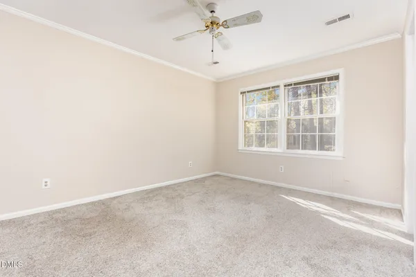 an empty room with windows and fan