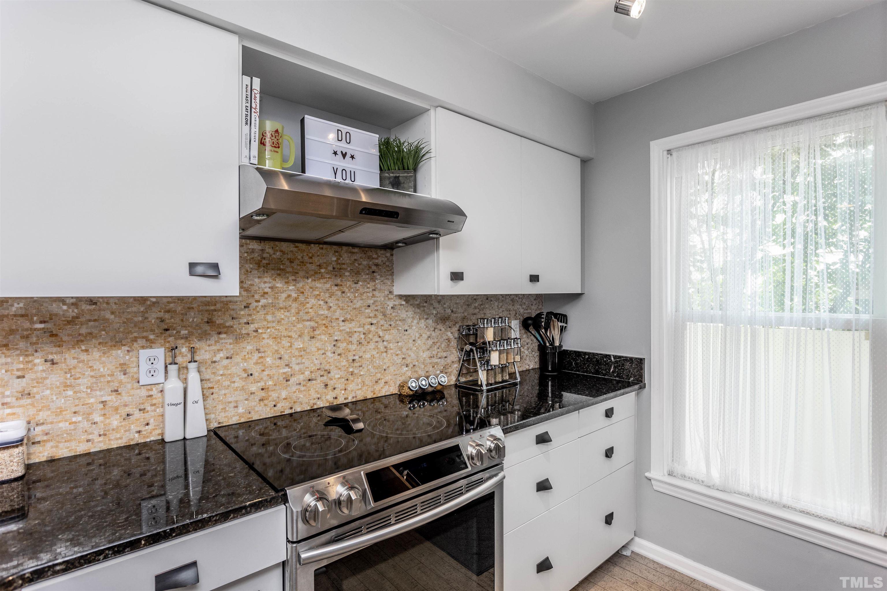 1024 Brighthurst Drive, Unit 1024 Raleigh, NC 27605 - Photo 5 of 30 a kitchen with granite countertop a stove and a sink