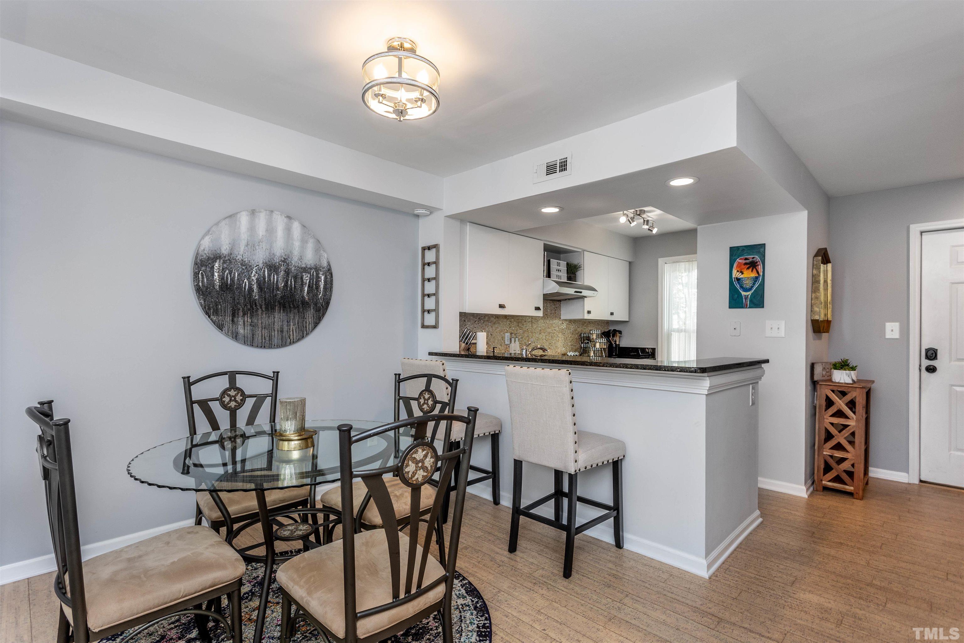 1024 Brighthurst Drive, Unit 1024 Raleigh, NC 27605 - Photo 10 of 30 a view of a dining room with furniture and a chandelier
