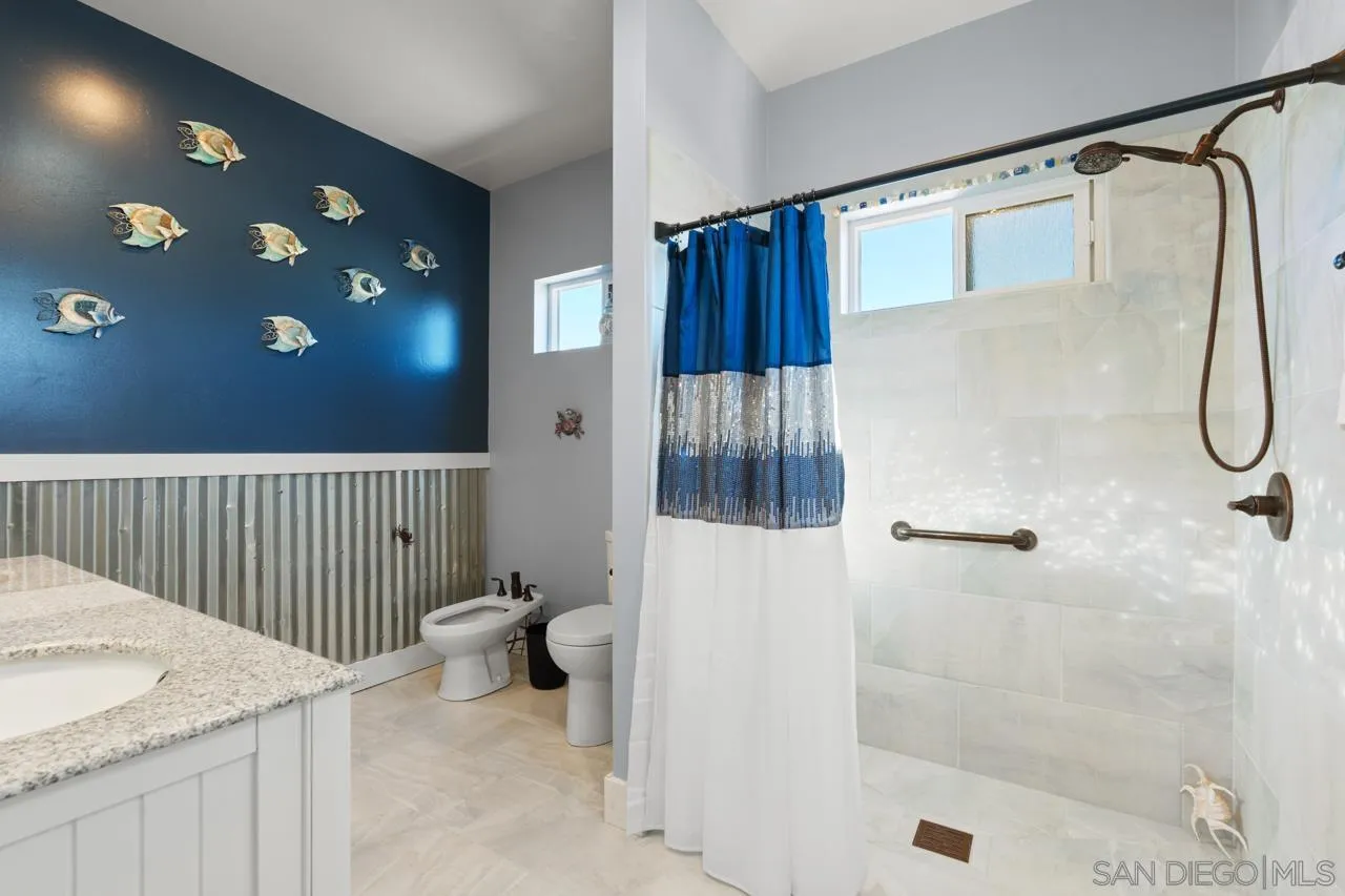 413 Delaware Street Imperial Beach, CA 91932 - Photo 27 of 37 a bathroom with a granite countertop sink a toilet and shower