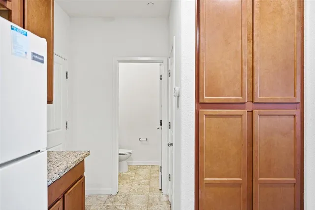 a bathroom with a granite countertop sink and a toilet