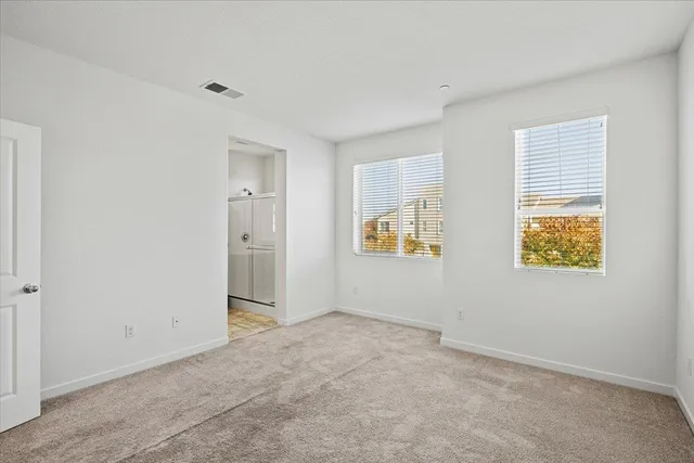 a view of an empty room with window and cabinet