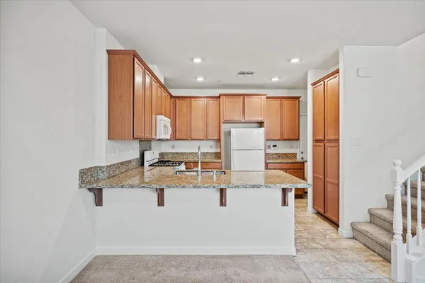 a kitchen with stainless steel appliances granite countertop a refrigerator sink stove and microwave
