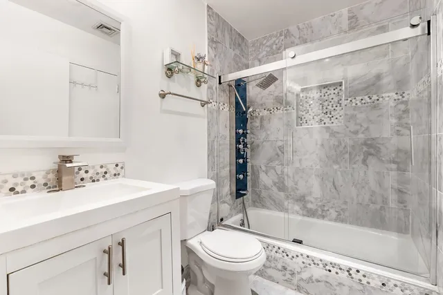 a bathroom with a sink mirror toilet and bathtub