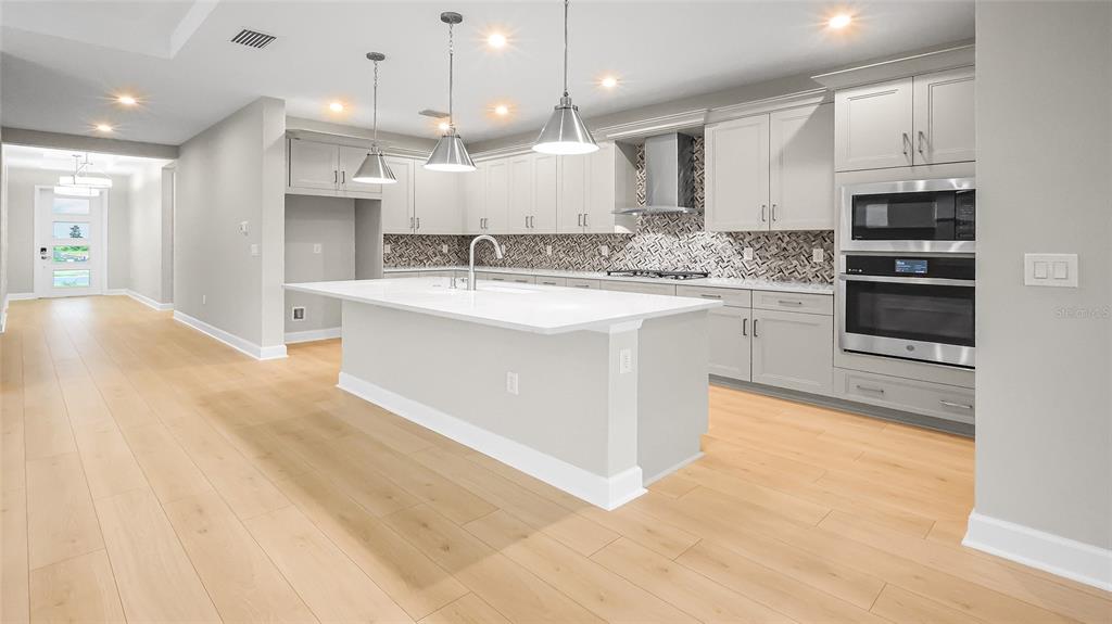 1620 Bellagio Loop Tavares, FL 32778 - Photo 13 of 81 a kitchen with kitchen island a sink stainless steel appliances and cabinets