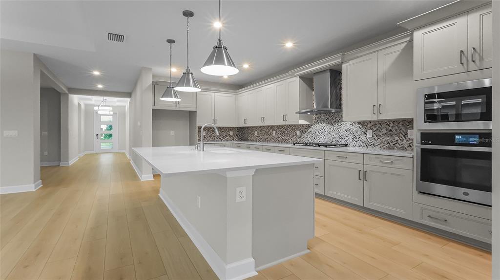 1620 Bellagio Loop Tavares, FL 32778 - Photo 18 of 81 a kitchen with stainless steel appliances kitchen island granite countertop a sink a stove top oven a counter space and cabinets