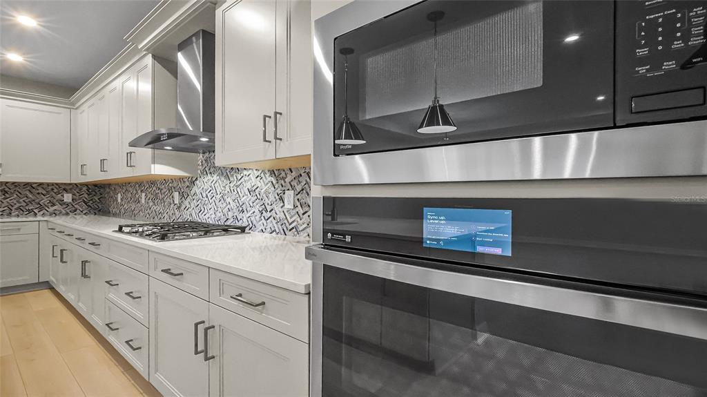 1620 Bellagio Loop Tavares, FL 32778 - Photo 21 of 81 a kitchen with stainless steel appliances kitchen island granite countertop a stove a sink and a microwave