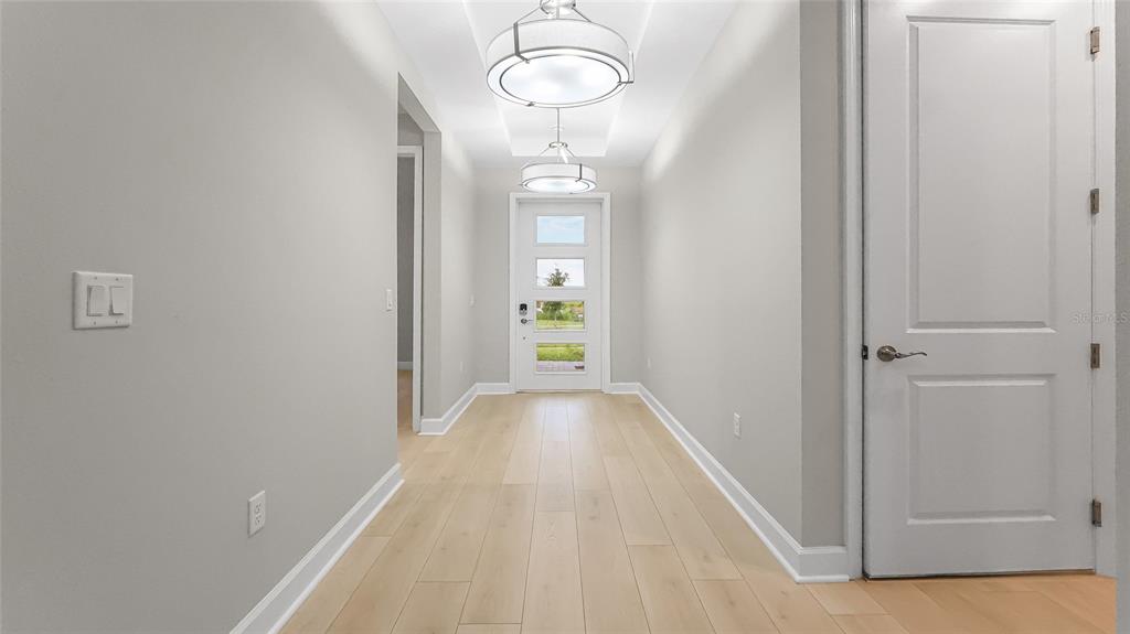 1620 Bellagio Loop Tavares, FL 32778 - Photo 5 of 81 a view of a hallway with wooden floor and chandelier