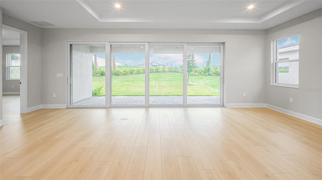 1620 Bellagio Loop Tavares, FL 32778 - Photo 9 of 81 a view of an empty room with wooden floor and a window