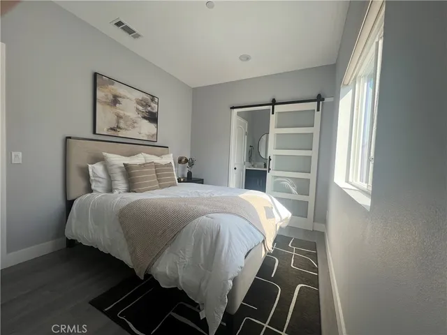 a bedroom with a bed and painting on the wall
