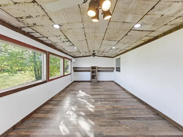 a view of a room with a wooden floor and windows