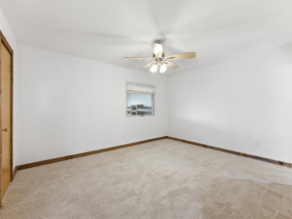 116 County Road 1559 Alba, TX 75410 - Photo 17 of 40 an empty room with a chandelier fan and windows