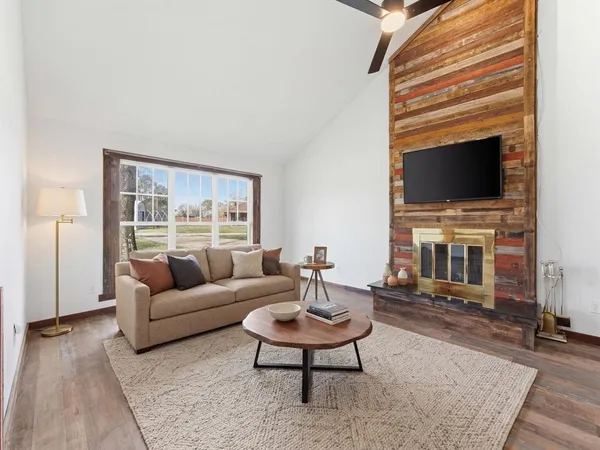 a living room with furniture a flat screen tv and a fireplace