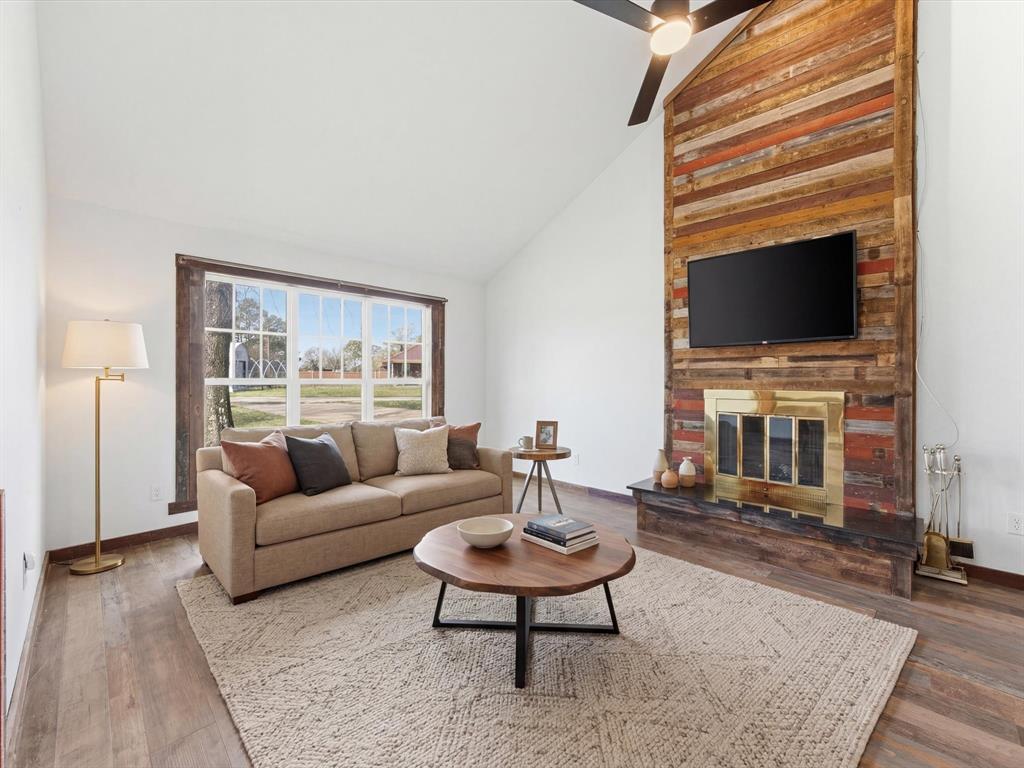116 County Road 1559 Alba, TX 75410 - Photo 5 of 40 a living room with furniture a flat screen tv and a fireplace