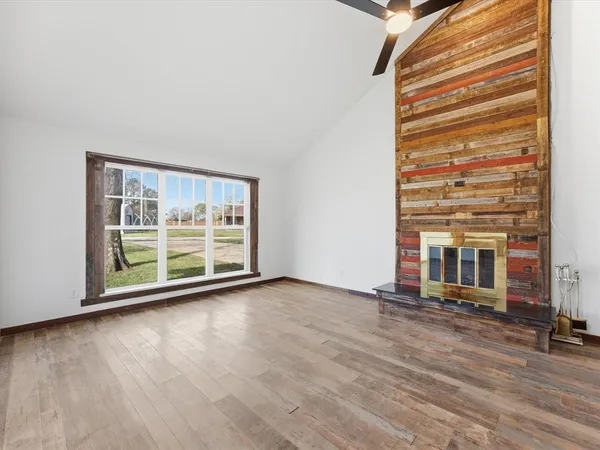 a view of a room with wooden floor and a large window