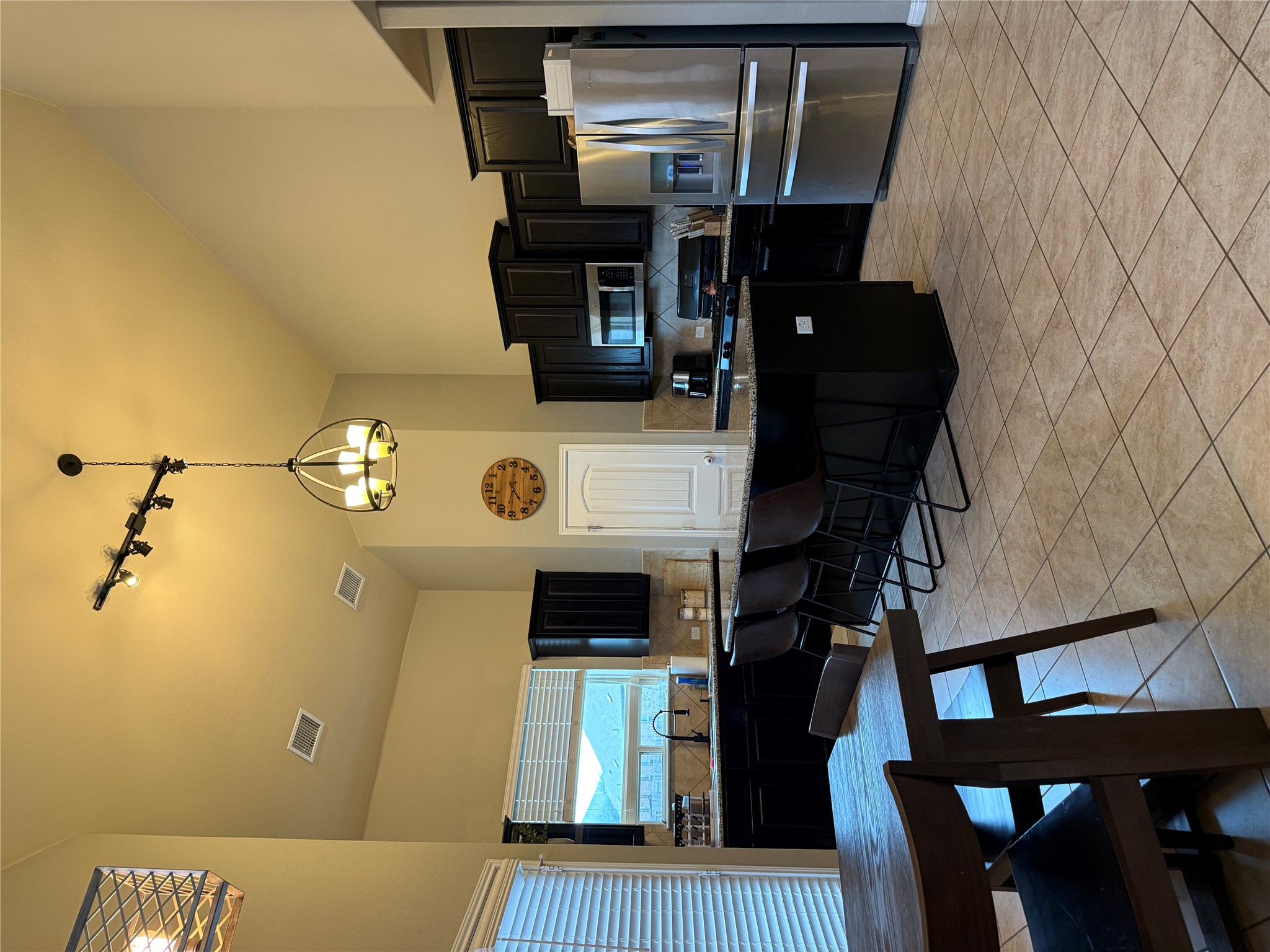1529 Hamiltons Way Leander, TX 78641 - Photo 4 of 15 a kitchen with a table chairs microwave and refrigerator