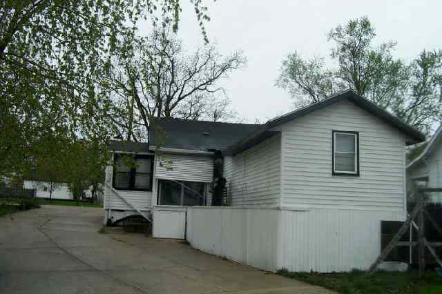 207 Washington Street Ridott, IL 61067 - Photo 3 of 8 a view of a white house with a large tree and wooden fence