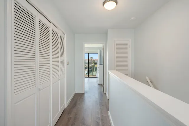 a view of a hallway with wooden floor and staircase