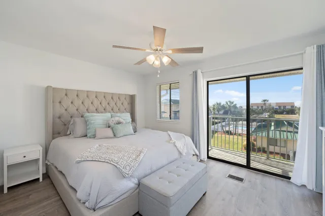 a bedroom with a large bed and a chandelier fan