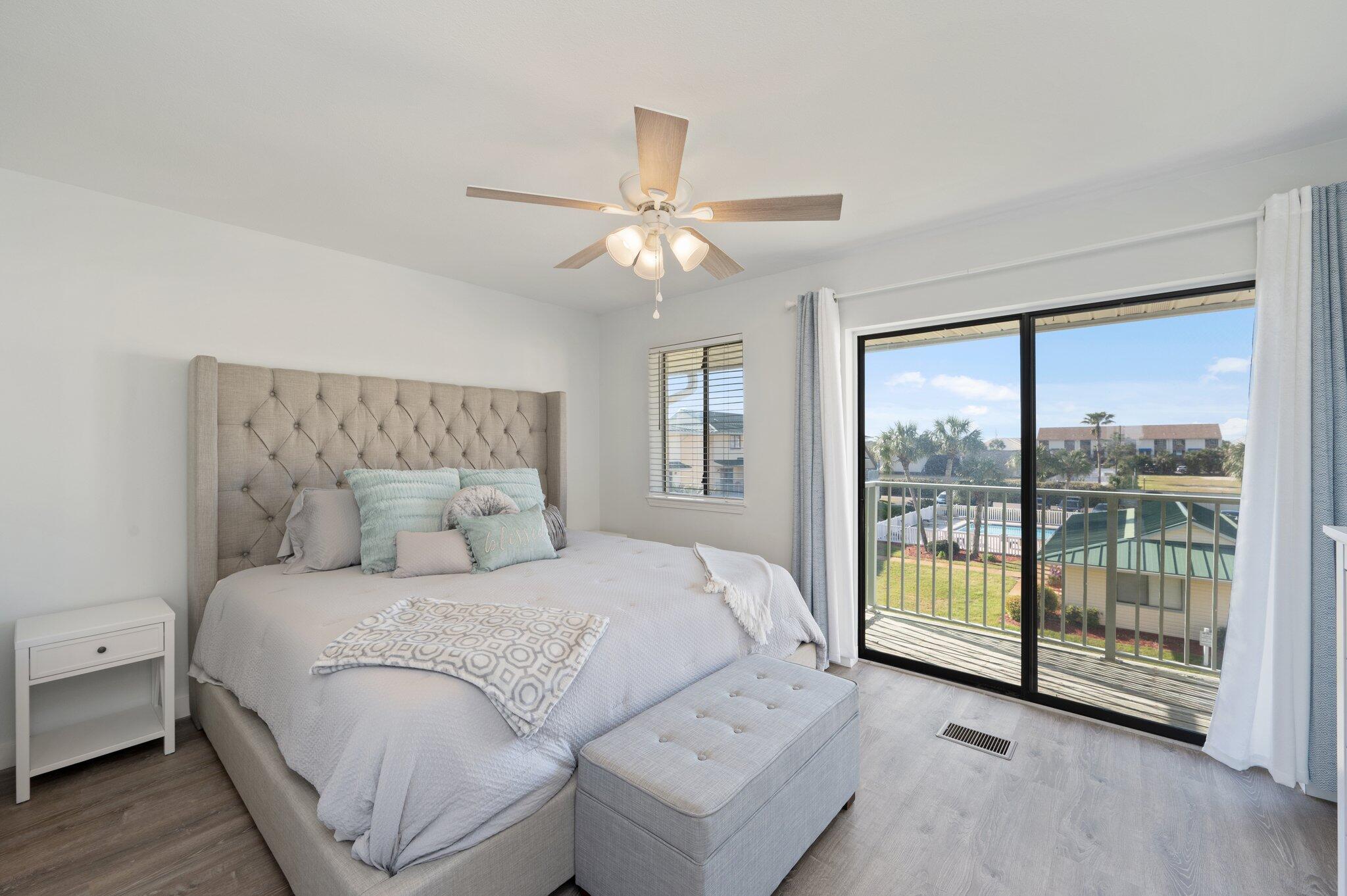 60 Sandprints Drive, Unit C6 Miramar Beach, FL 32550 - Photo 15 of 28 a bedroom with a large bed and a chandelier fan