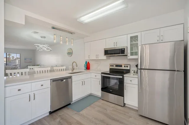 a kitchen with white cabinets and stainless steel appliances