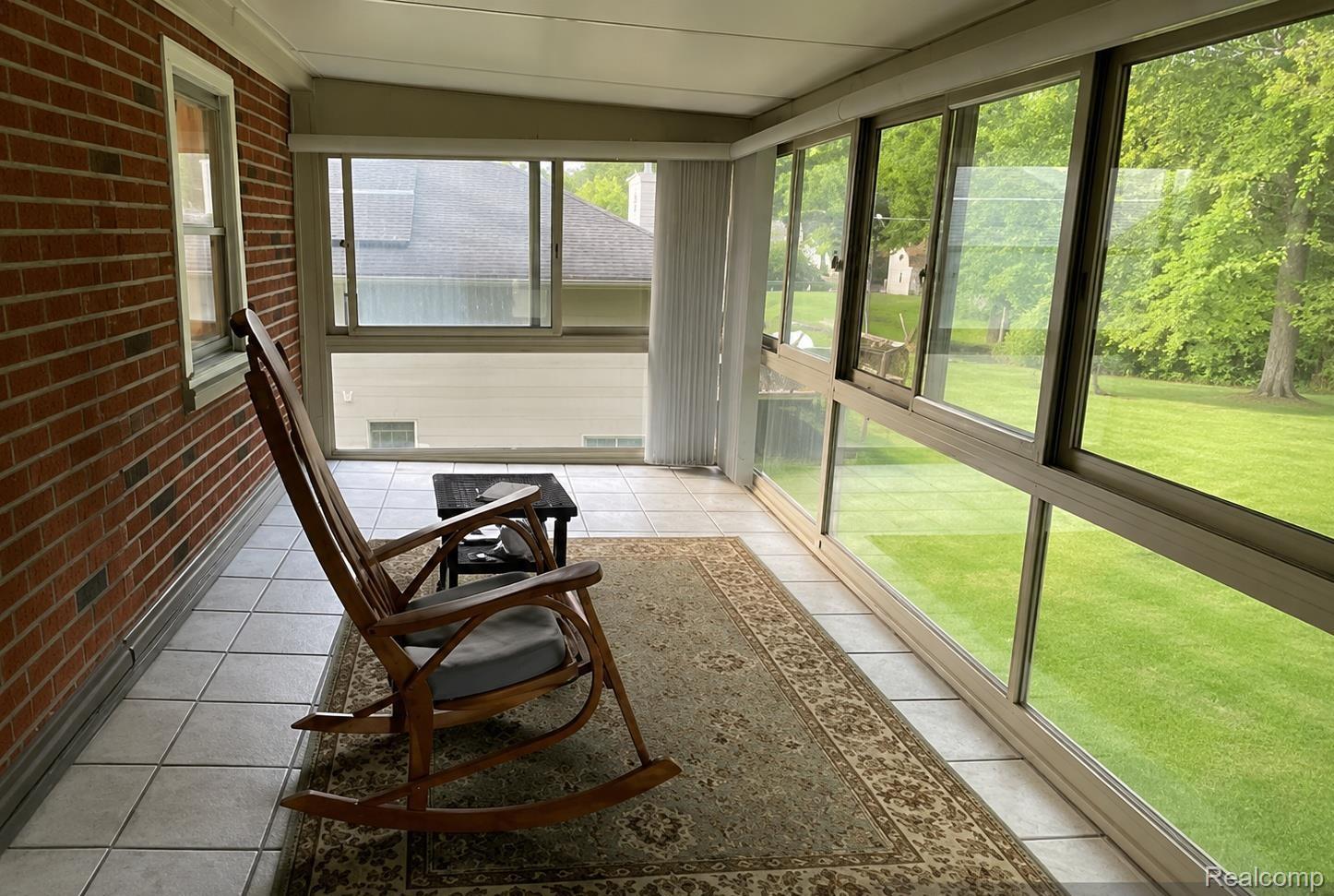 9552 Wayne Road Livonia, MI 48150 - Photo 16 of 31 three-season room overlooking the lush backyard, offering a unique retreat space ideal for morning coffee, reading, relaxing, or enjoying the changing seasons from the comfort of indoors.