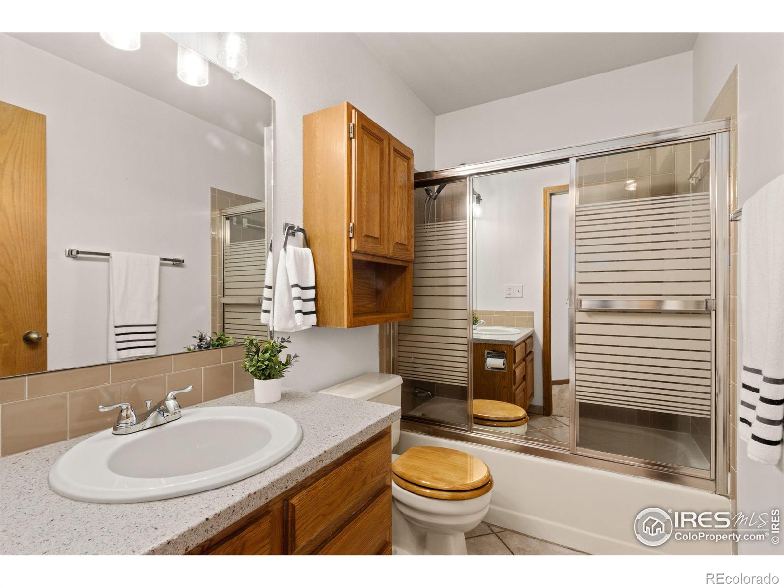 3367 Dudley Way Fort Collins, CO 80526 - Photo 16 of 29 a bathroom with a sink a toilet a mirror and shower