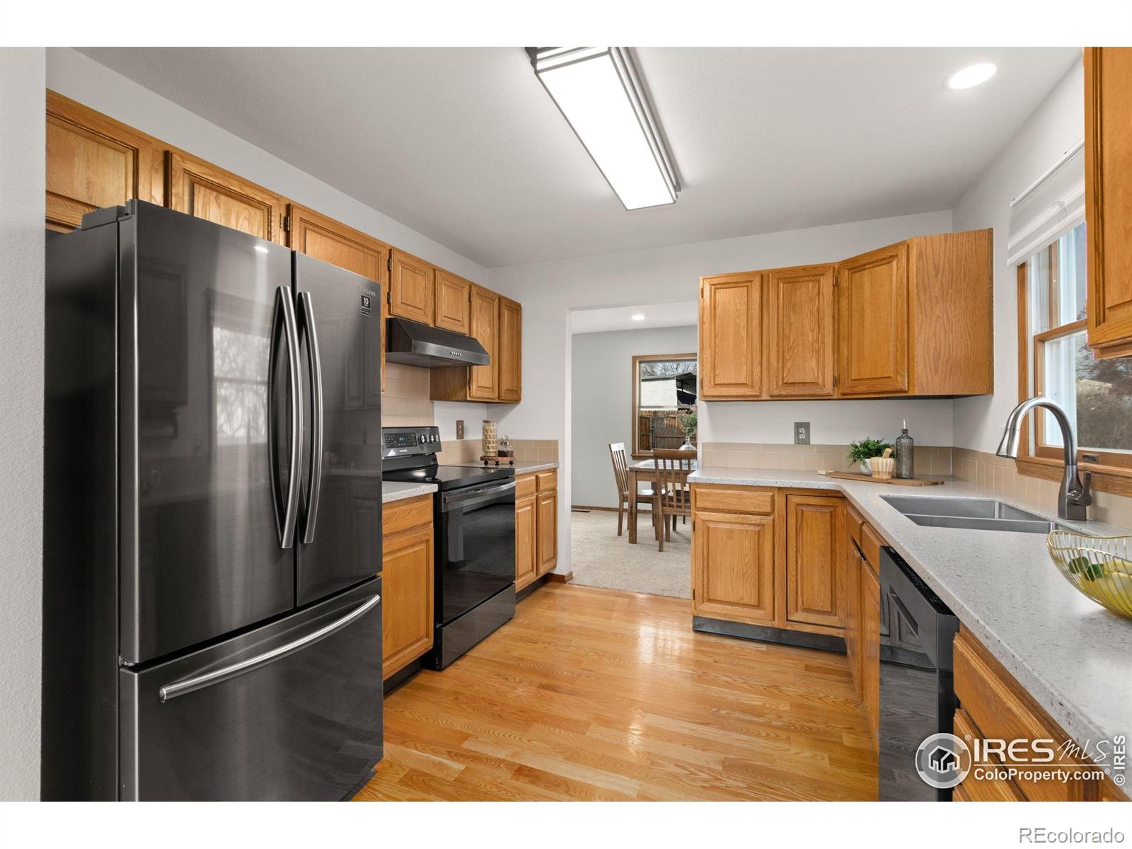 3367 Dudley Way Fort Collins, CO 80526 - Photo 7 of 29 a kitchen with stainless steel appliances granite countertop a refrigerator stove microwave and sink