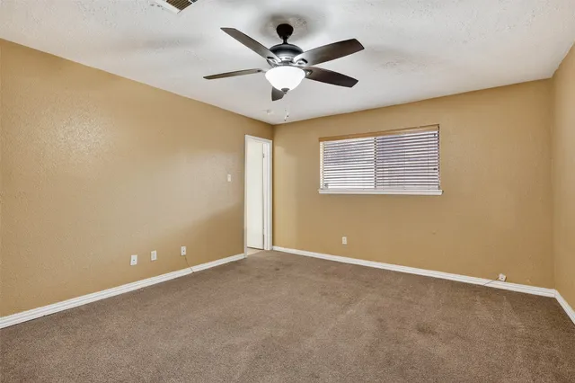 a view of an empty room with a ceiling fan