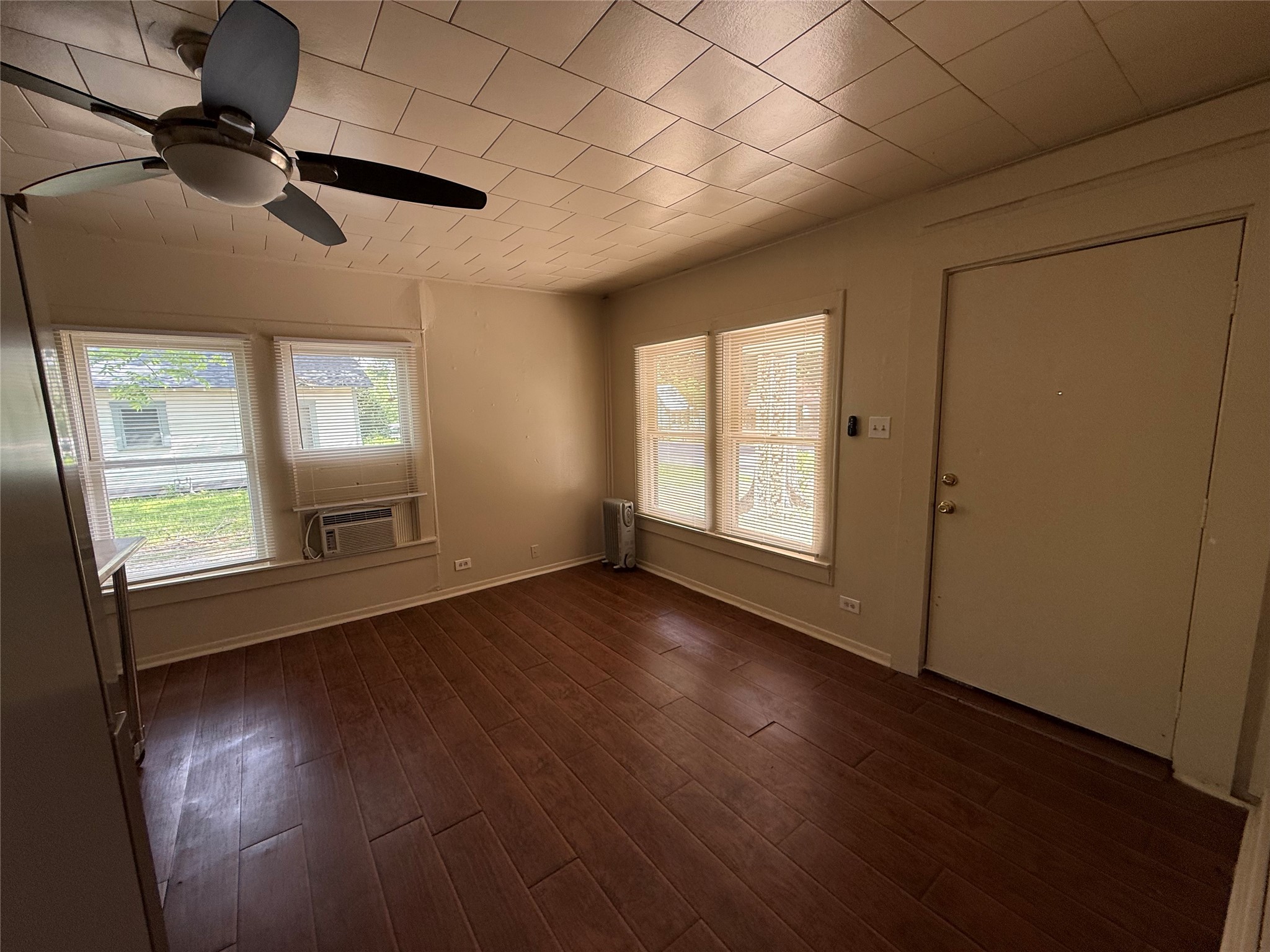 2812 Angier Road Huntsville, TX 77340 - Photo 2 of 6 an empty room with wooden floor fan and windows