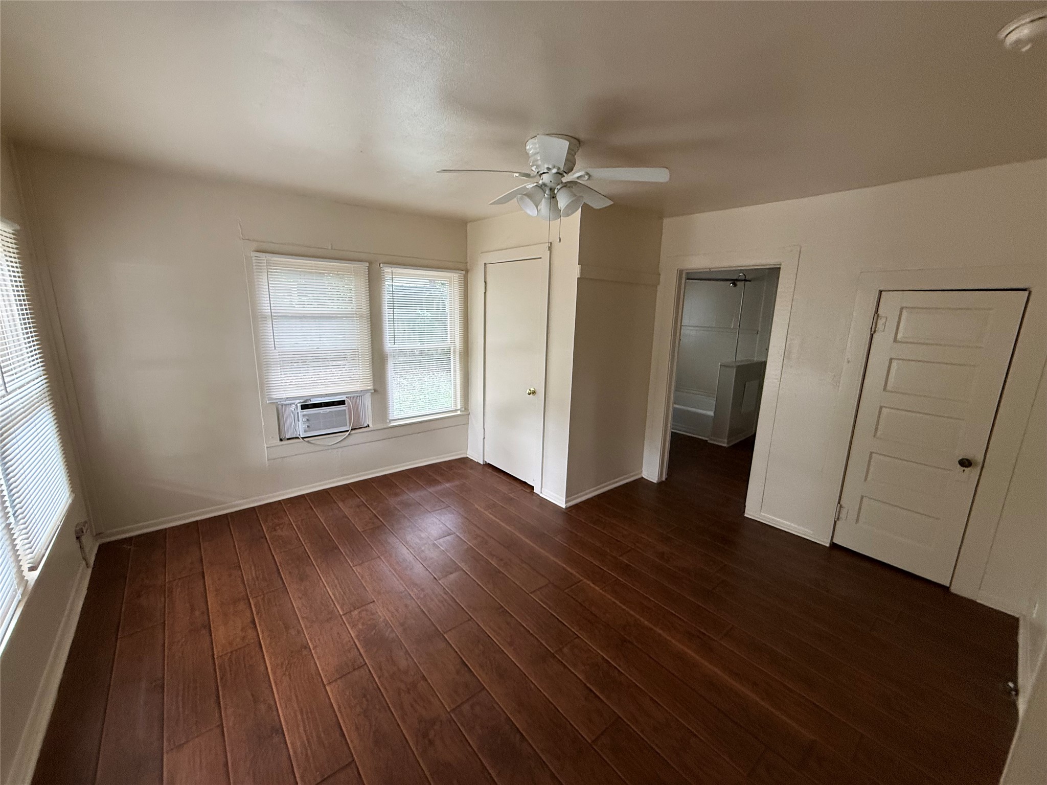 2812 Angier Road Huntsville, TX 77340 - Photo 4 of 6 an empty room with wooden floor and windows