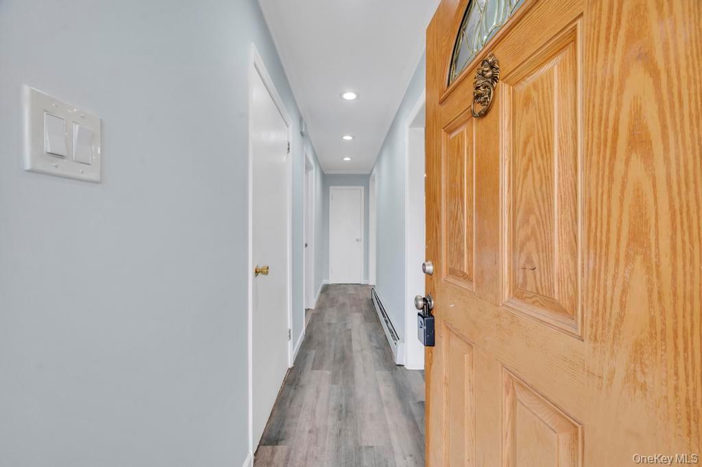 63 Blacksmith Road Levittown, NY 11756 - Photo 4 of 25 Corridor featuring recessed lighting, wood finished floors, and a baseboard heating unit