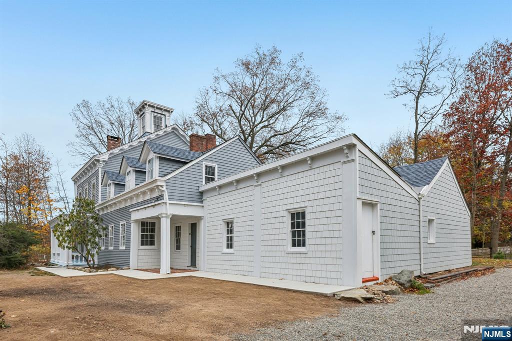 142 Island Road Mahwah, NJ 07430 - Photo 2 of 46 a view of a white house with a large tree and wooden fence