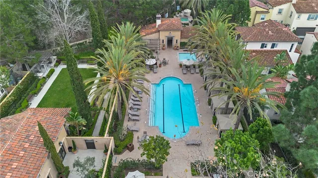 an aerial view of a house with outdoor space and trees all around