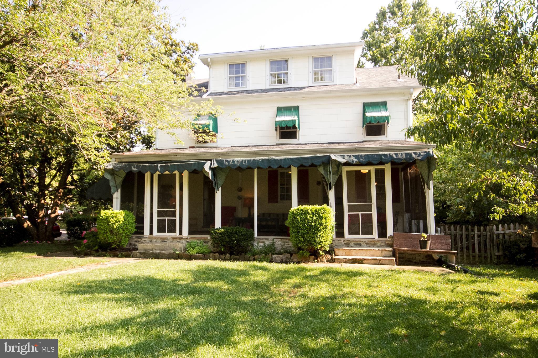 601 Dunkirk Road Baltimore, MD 21212 - Photo 20 of 22 a view of a white house with a large windows and a yard with plants and large trees