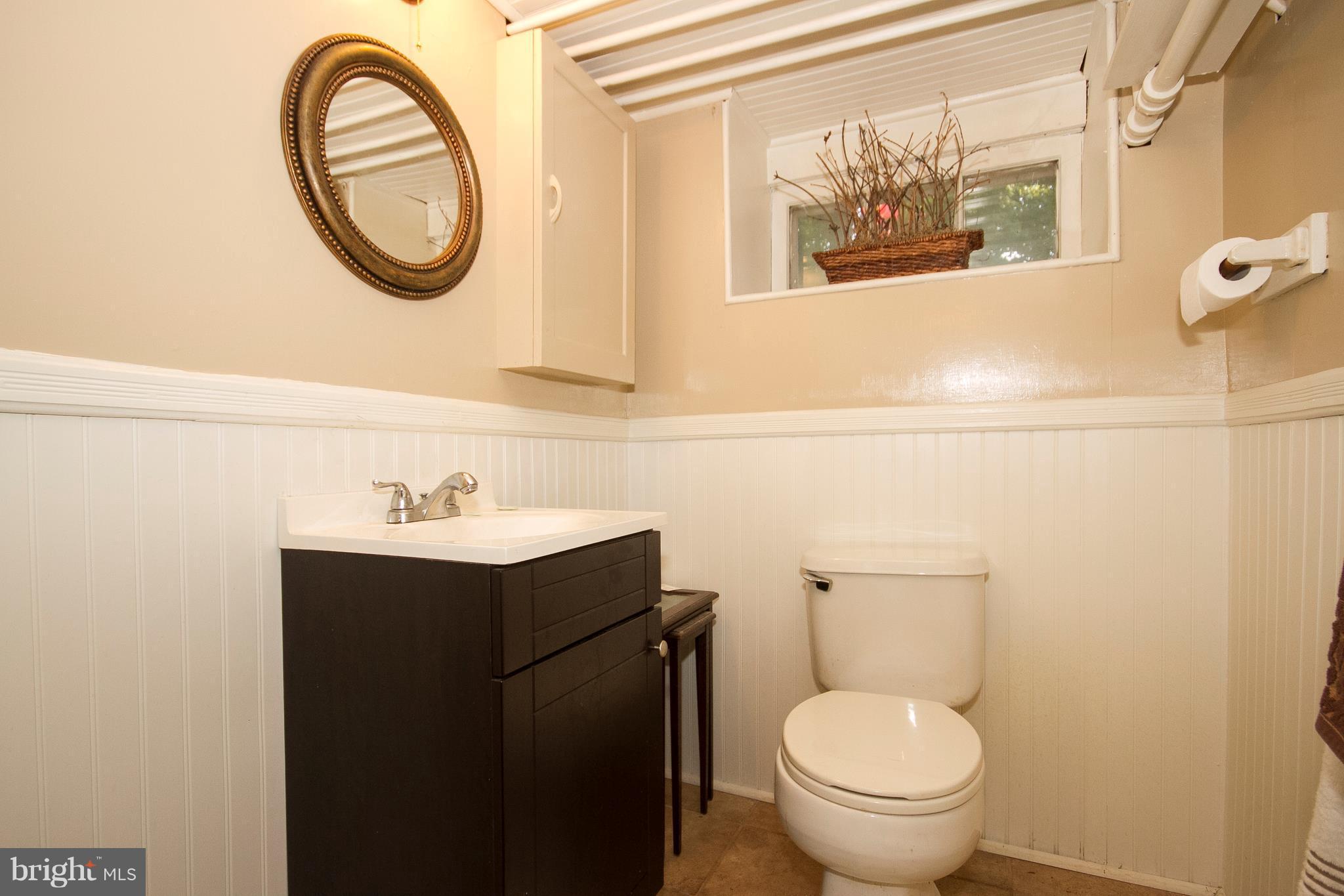 601 Dunkirk Road Baltimore, MD 21212 - Photo 10 of 22 a bathroom with a toilet a sink and a mirror