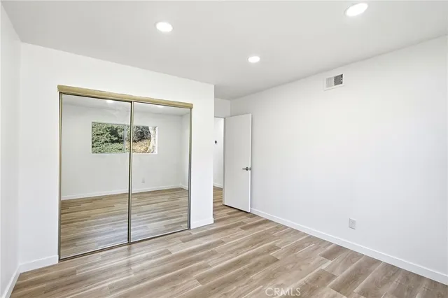 a view of a closet area with wooden floor