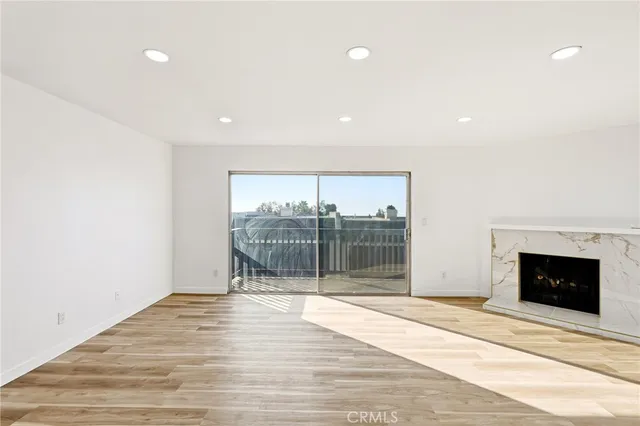 a view of empty room with wooden floor and fireplace