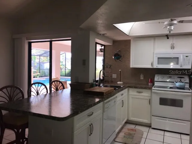 a kitchen with sink a stove and cabinets