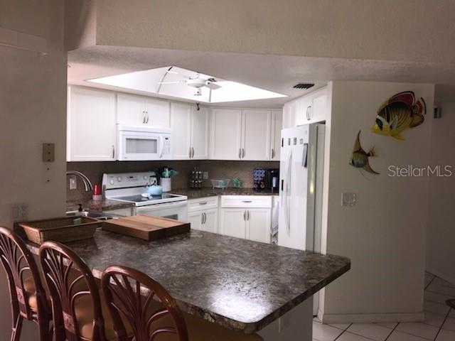 7160 Carlsbad Terrace Englewood, FL 34224 - Photo 6 of 19 a kitchen with stainless steel appliances granite countertop a sink refrigerator stove and microwave