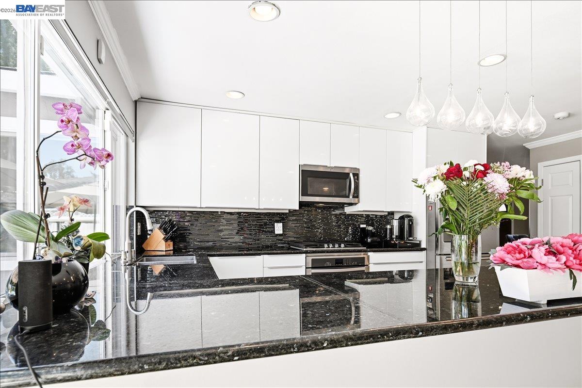 2861 Millbridge Place San Ramon, CA 94583 - Photo 19 of 58 a kitchen with stainless steel appliances kitchen island granite countertop a stove a sink and a microwave