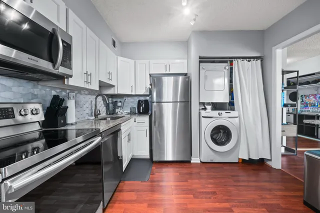 a kitchen with a stove top oven a refrigerator and cabinets